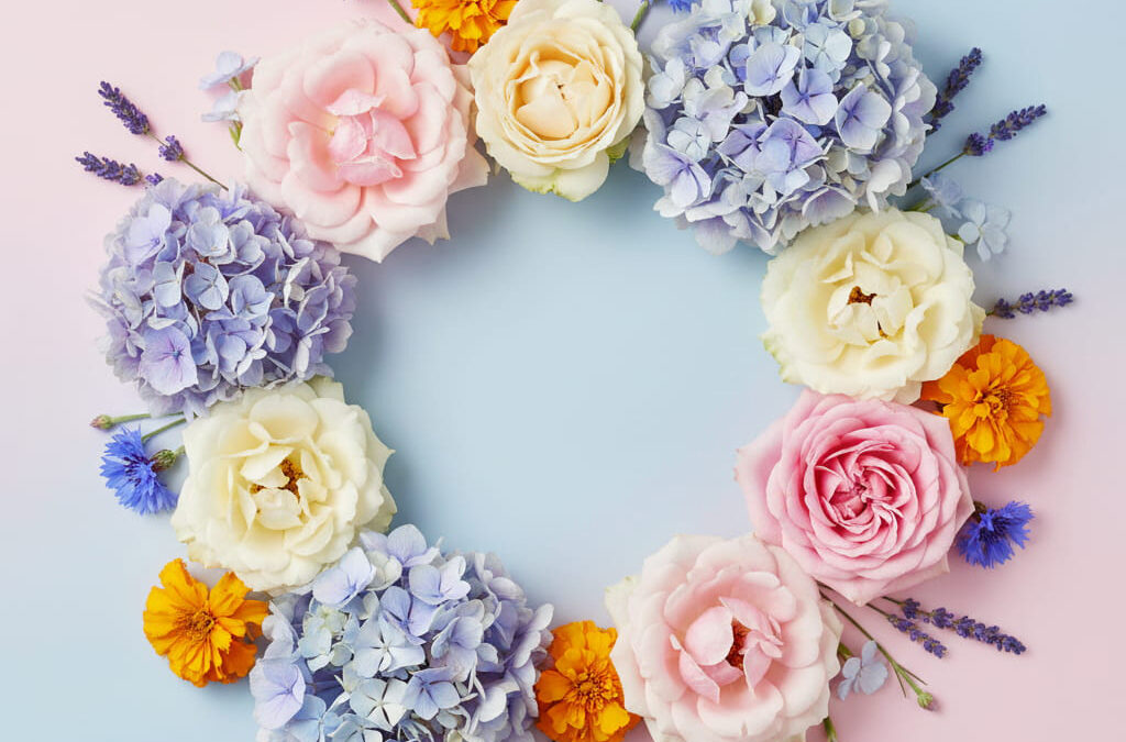 Farbenfrohe Auswahl frischer Blumen wie Rosen, Hortensien, Kornblumen und Lavendel in einer dekorativen Anordnung.